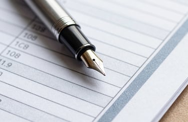 A macro shot of a fountain pen resting on a detailed financial report. The paper shows columns of data and clean, greyish-blue borders. The lighting is crisp, highlighting the high-quality texture of the paper.
