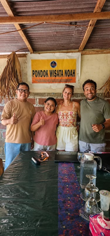 A group of happy travelers giving thumbs up at Pondok Wisata Noah guest house in Indonesia.