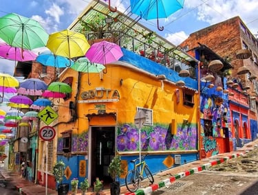 Colorful colonial house under hanging umbrellas near Chorro de Quevedo during a private La Candelaria tour