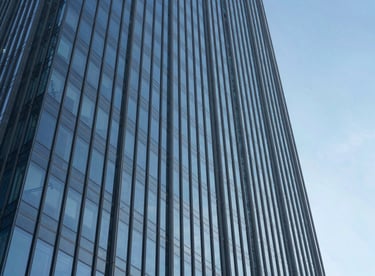 Abstract view of a glass and steel International / Global skyscraper reflecting a clear blue sky, emphasizing precision and growth.