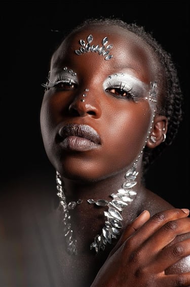 Model wearing silver metallic makeup and decorative face crystals for a glam fashion portrait.