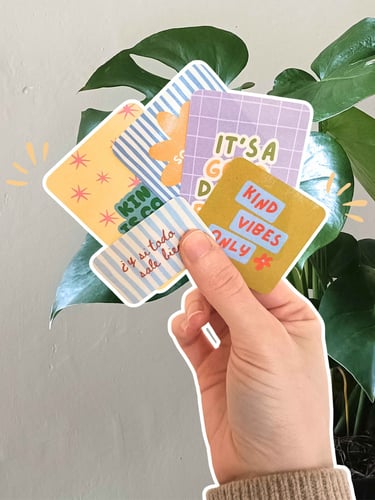 Mano con stickers coloridas de papeleria creativa