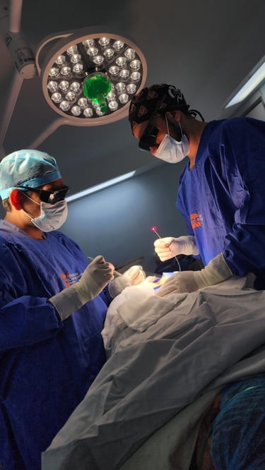 Surgeons performing a laser surgery procedure in an operating room under bright surgical lights.