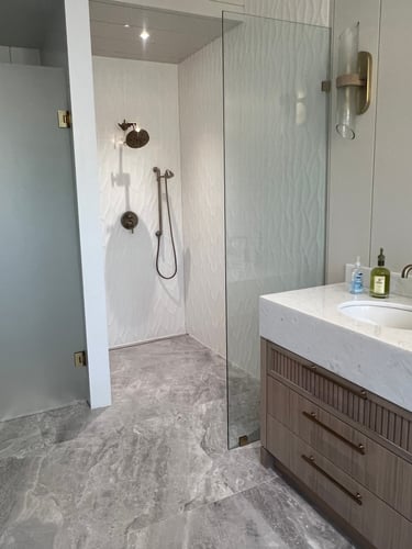Modern bathroom featuring a walk-in glass shower, large format tile on floors and walls.