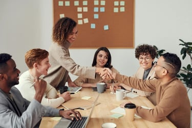 Diverse business team shaking hands during a successful project meeting in a modern office.