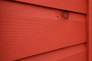 de la peinture suedoise rouge proche du rouge de falun peint sur des planches de bois exterieur en gros plan