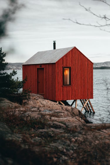 de la peinture suedoise rouge sur un chalet en bois au bord de l'eau