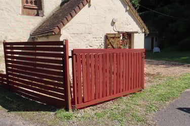 Application d’une peinture naturelle sur une clôture bois pour une protection durable et écologique.