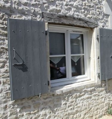 Des volet en bois gris avec une peinture naturelle moins chère à l'achat et en simple en entretien