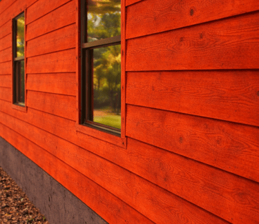 un bardage en bois brut peint avec de la peinture suedoise rouge monocouche