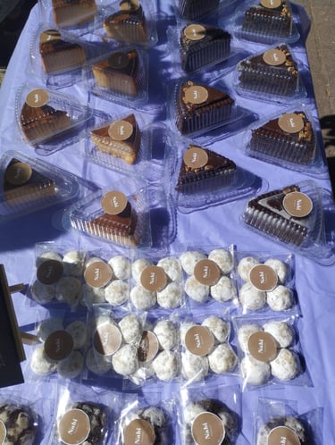 Surtido de rebanadas de pastel gourmet y galletas espolvoreadas con azúcar glass, presentadas en emp