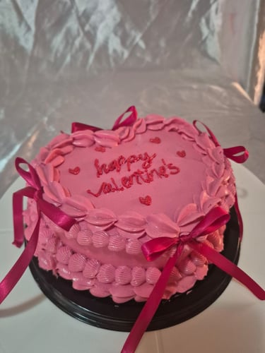 Pastel rosa en forma de corazón con estilo vintage, listones y letras decoradas a mano.