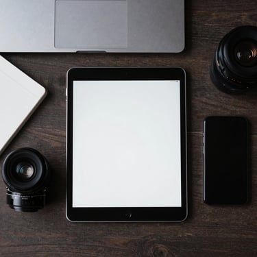 A professional top-down shot of a minimalist desk setup in North America with a tablet, a sleek smartphone, and a notepad, tech-inspired aesthetic.