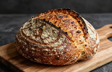 A close-up shot of freshly baked artisanal sourdough bread on a rustic wooden board in a North American / Western bakery.