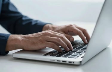A close-up of a man's hands typing on a high-tech laptop. The scene is lit with cool, pale icy white light, emphasizing a professional and focused atmosphere.