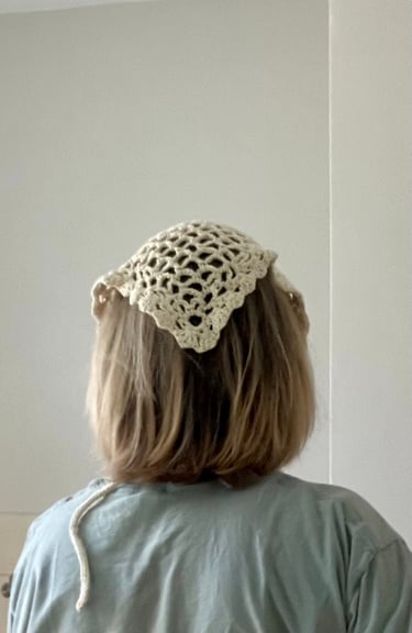 Model wearing crochet head scarf over her head