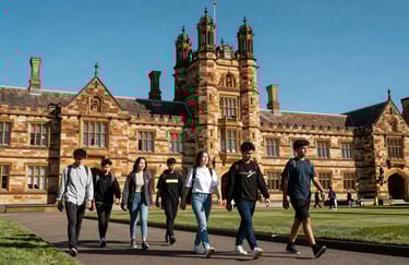 A group of international students walking through a historic Australian sandstone university campus under a bright blue sky.