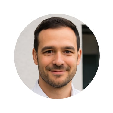 Professional headshot of a smiling man with short dark hair and a beard in a circular frame.