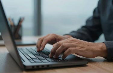 Close-up of a professional's hands typing on a high-tech keyboard in a North American / US office, with soft sky blue ambient lighting.