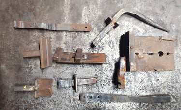 Tradiciniai kalviški įrankiai metalo formavimui, išdėlioti kalvystės dirbtuvėse