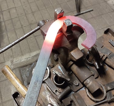 Įkaitinto metalo formavimas ir lenkimas kalvystės dirbtuvėse.