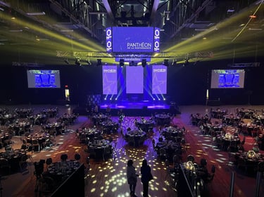 Grand gala ballroom setup for Pantheon de la Performance corporate event with stage lighting and banquet tables.