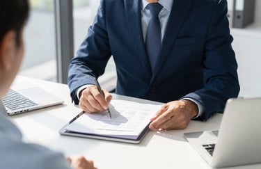 A professional financial advisor reviewing documents on a tablet with a client in a sunlit, modern North American office. The focus is sharp on the data and the collaborative interaction. Palette includes deep navy and light blue.