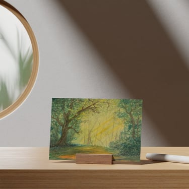 Aquarell-Waldgemälde mit Sonnenstrahlen auf einem Holzständer in einem hellen, minimalistischen Inte