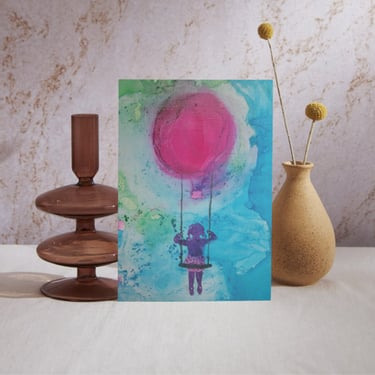 Aquarell-Kunstkarte eines Kindes auf einer Schaukel, das mit einem rosa Heißluftballon schwebt.