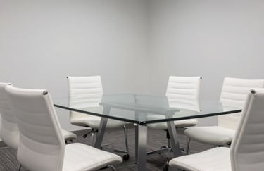 A modern bright conference room with a glass table, North American / International, clean professional atmosphere with minimalist white chairs.