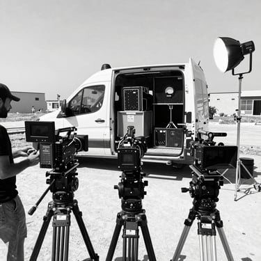 A close-up of a professional cinematic camera lens with minimal reflections, shot in a high-contrast black and white style. The focus is on the precision of the equipment, utilizing #0A0A0A and #D9D9D9.