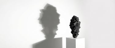 Sculpture Pyrite noire monochrome sur socle blanc, ombre portée sur mur