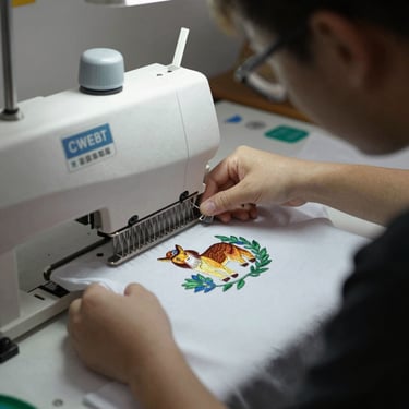 A designer reviewing digital prints on fabric swatches in a bright studio.