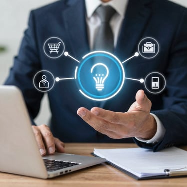 Businessman using a laptop with digital lightbulb icon and business strategy symbols.