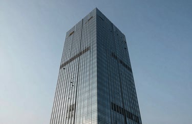 An exterior view of a modern glass office skyscraper in Ahmedabad city under a clear sky, symbolizing growth and industrial connectivity.