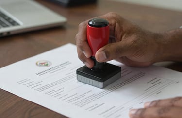 A close-up photography shot of hands stamping official logistics documents in a professional South Asian office setting, representing trust.