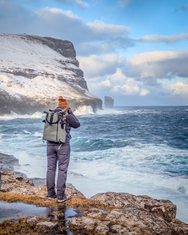 Photographer capturing crashing waves in the Faroe Islands