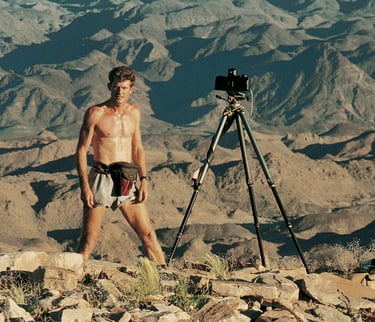 Koos van der Lende, landscape photographer standing on the edge of a canyon setting up a photograph using a tripod