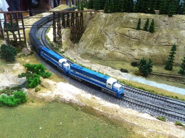 A passenger train headed by two EMD demo locomotives run into Dog River on Moose Jaw