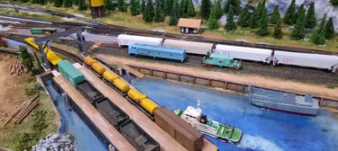 A tug is holding a full rail barge for unloading at Fort McCloud