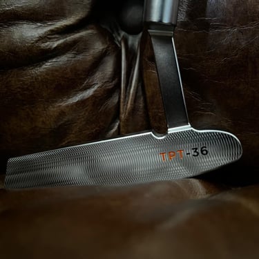 Brace forged golf putter on leather