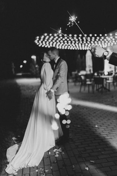 Jaunieji bučiuojasu susikabinę rankomis - dokumentinė vestuvių fotografija