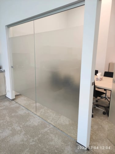 Stumdomos biuro durys dengtos matine plėvele su minimalistiniu užrašu, tinkančios šiuolaikiškam interjerui