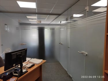 Viršutinės stiklo dalys biure padengtos matine plėvele, kuri užtikrina šviesos sklaidą ir privatumą