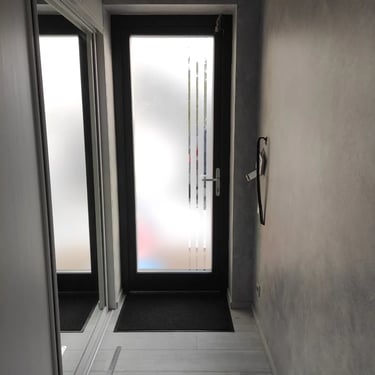 Įėjimo durys dengtos matine plėvele su dekoratyvinėmis juostomis, sukuriantis šiuolaikinį dizainą