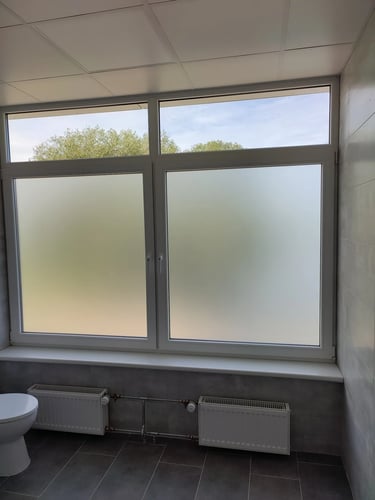 Komercinio pastato durys ir vitrininiai langai padengti matine plėvele dėl privatumo