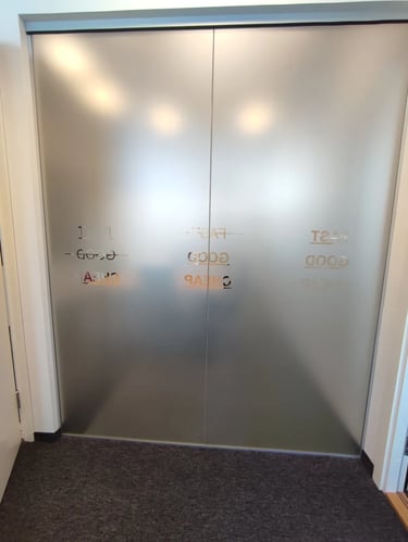 Stiklinė pertvara su matine plėvele komercinio pastato fasade, sauganti privatumą ir šviesą