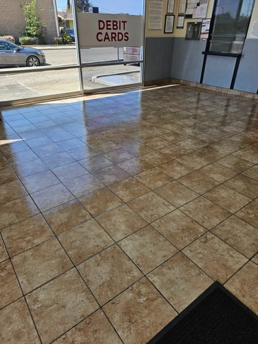 Clean and shiny commercial ceramic tile flooring reflecting light inside a business lobby.