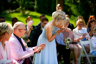 Hochzeitsgäste beteiligen sich an einem Ritual während einer freien Trauung im Freien.