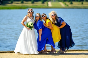 Lustiges Hochzeitsfoto: Frauenclique posiert mit weißen Sonnenbrillen.